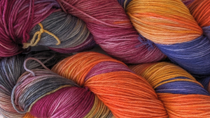 Skeins with a mix of reds, oranges, greys, and blues, inspired by a beautiful desert sunset.